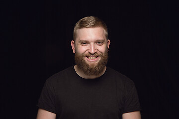 Image showing Close up portrait of young man isolated on black studio background