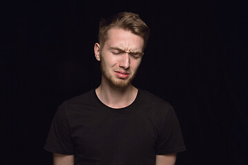 Image showing Close up portrait of young man isolated on black studio background