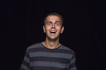 Image showing Close up portrait of young man isolated on black studio background