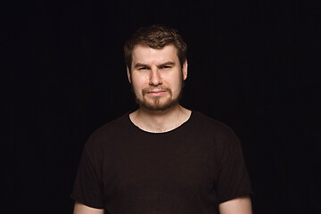 Image showing Close up portrait of young man isolated on black studio background