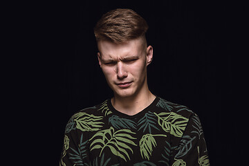 Image showing Close up portrait of young man isolated on black studio background