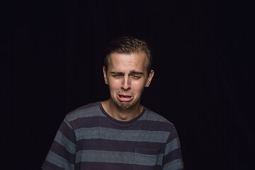 Image showing Close up portrait of young man isolated on black studio background