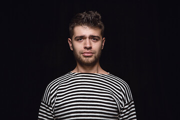 Image showing Close up portrait of young man isolated on black studio background