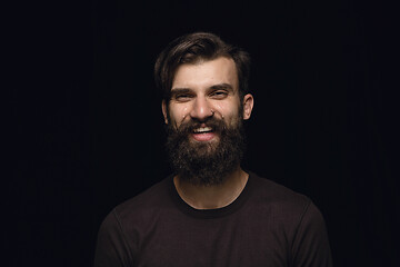 Image showing Close up portrait of young man isolated on black studio background