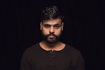 Image showing Close up portrait of young man isolated on black studio background