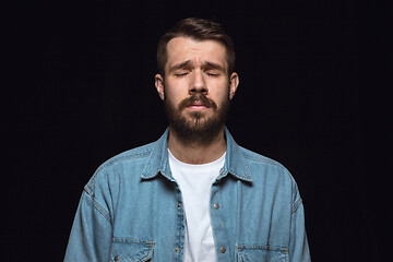 Image showing Close up portrait of young man isolated on black studio background