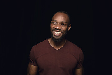 Image showing Close up portrait of young man isolated on black studio background