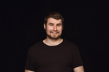 Image showing Close up portrait of young man isolated on black studio background