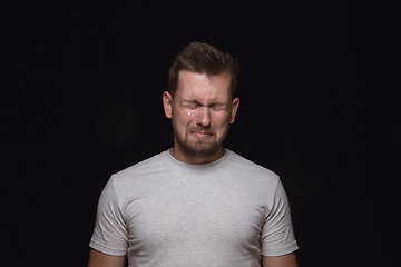 Image showing Close up portrait of young man isolated on black studio background