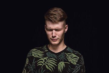 Image showing Close up portrait of young man isolated on black studio background