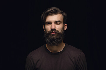 Image showing Close up portrait of young man isolated on black studio background