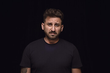 Image showing Close up portrait of young man isolated on black studio background