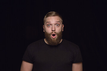 Image showing Close up portrait of young man isolated on black studio background