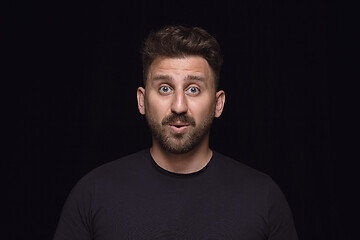 Image showing Close up portrait of young man isolated on black studio background