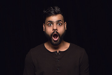 Image showing Close up portrait of young man isolated on black studio background