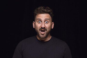 Image showing Close up portrait of young man isolated on black studio background