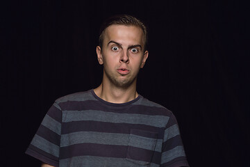 Image showing Close up portrait of young man isolated on black studio background