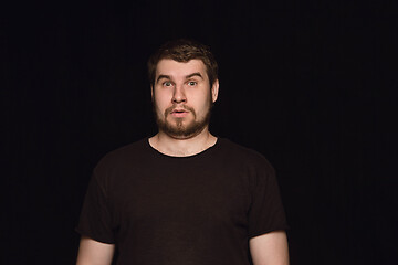 Image showing Close up portrait of young man isolated on black studio background