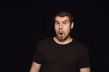 Image showing Close up portrait of young man isolated on black studio background