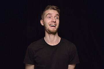 Image showing Close up portrait of young man isolated on black studio background