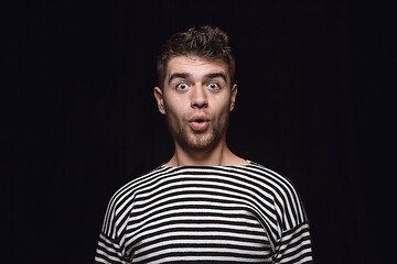 Image showing Close up portrait of young man isolated on black studio background