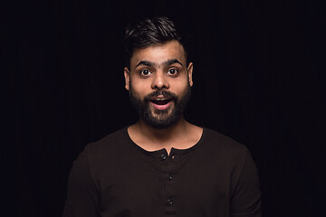 Image showing Close up portrait of young man isolated on black studio background