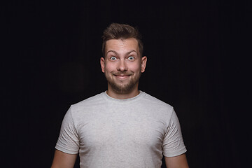 Image showing Close up portrait of young man isolated on black studio background