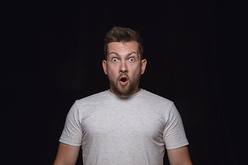 Image showing Close up portrait of young man isolated on black studio background