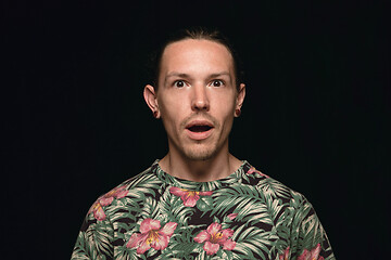 Image showing Close up portrait of young man isolated on black studio background