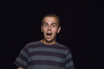 Image showing Close up portrait of young man isolated on black studio background