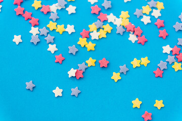 Image showing star shaped pastry sprinkles on blue background