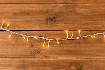 Image showing christmas garland lights on wooden background