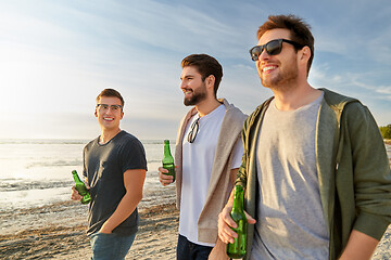 Image showing young men with non alcoholic beer walking on beach