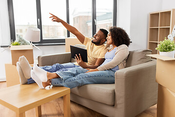 Image showing happy couple with tablet pc computer at new home