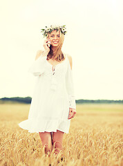 Image showing happy young woman calling on smartphone at country