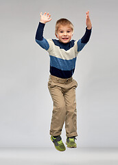 Image showing happy little boy jumping in air