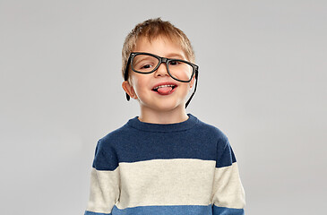 Image showing portrait of little boy in glasses showing tongue