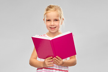 Image showing smiling little girl reading book