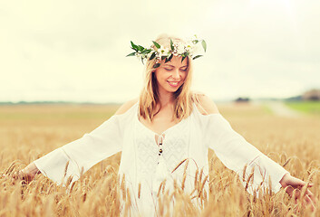 Image showing happy young woman in flower wreath on cereal field