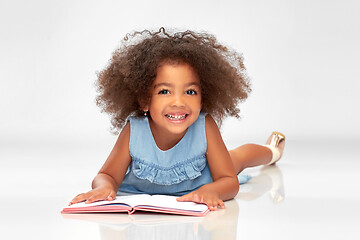 Image showing smiling little african american girl reading book