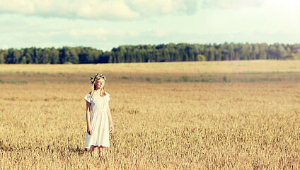 Image showing happy young woman in flower wreath on cereal field