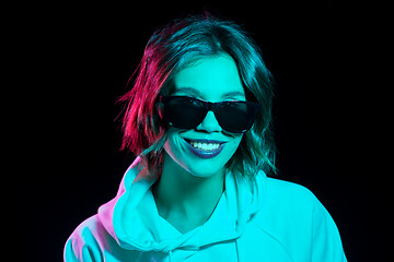 Image showing woman wearing hoodie in neon lights over black