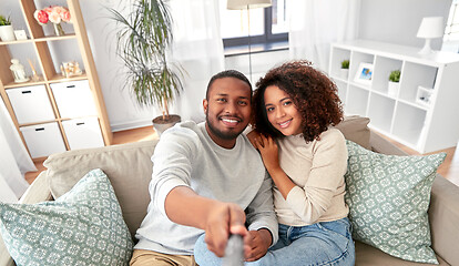 Image showing couple taking picture by selfie stick at home