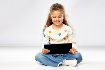 Image showing smiling girl with tablet computer sitting on floor