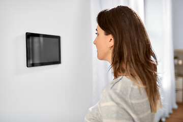 Image showing woman looking at tablet computer at smart home