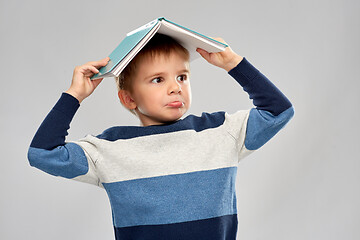 Image showing little boy with roof of book on top of his head