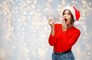 Image showing surprised woman in santa hat with money