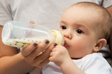 Image showing close up of mother feeding baby with milk formula