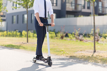 Image showing young businessman riding electric scooter outdoors