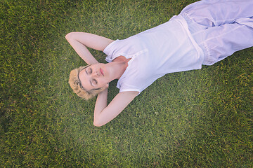 Image showing top view of young woman relaxing on the grass